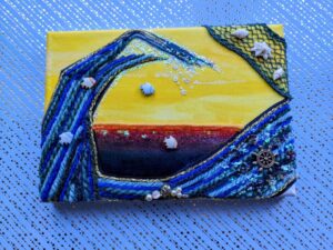 An acrylic mixed media painting of a woollen sea with fish jumping out of the water and a water wheel depicting the flow. With nets and shell added.